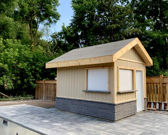 Natural stone slabs surrounding a wooden shed by pool area